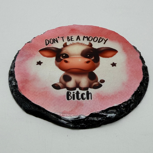 Round coaster with a cow illustration and text on a white background